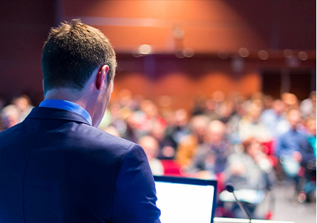 A man in a suit is sitting at a podium