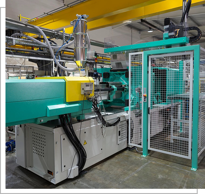 A machine in a factory with wires hanging from the ceiling.