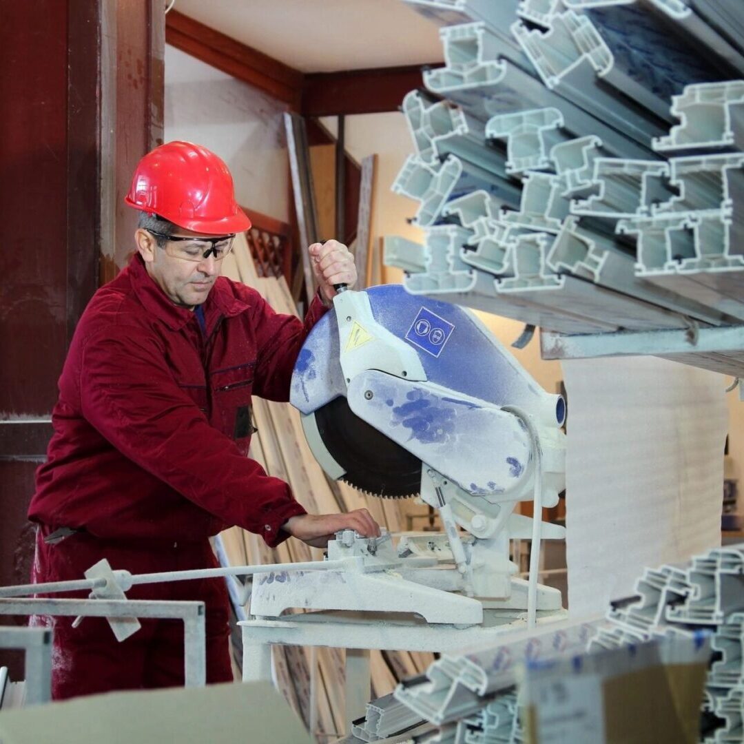 A man in red shirt and hard hat working.